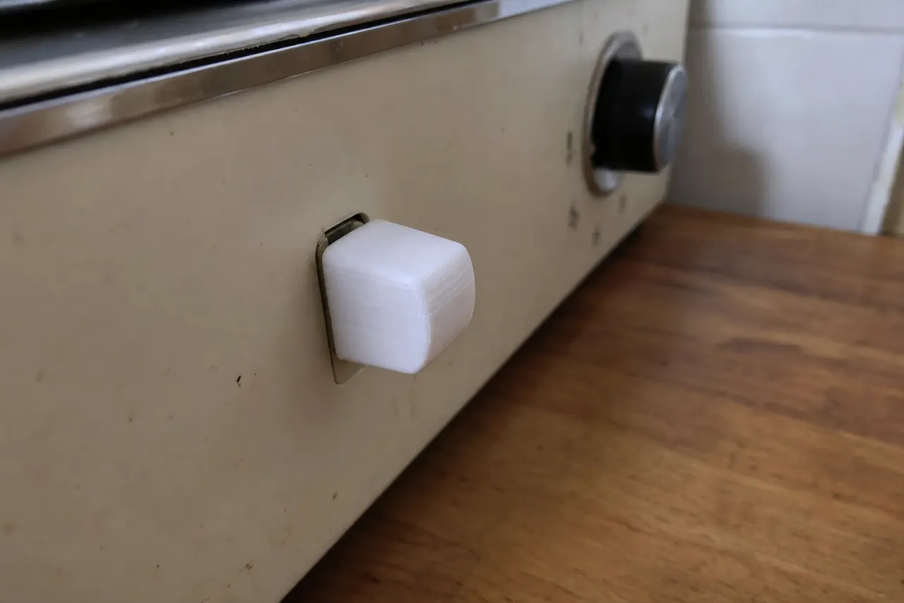 Hvit 3D-printet bryterknapp på et gammelt kjøkkenapparat