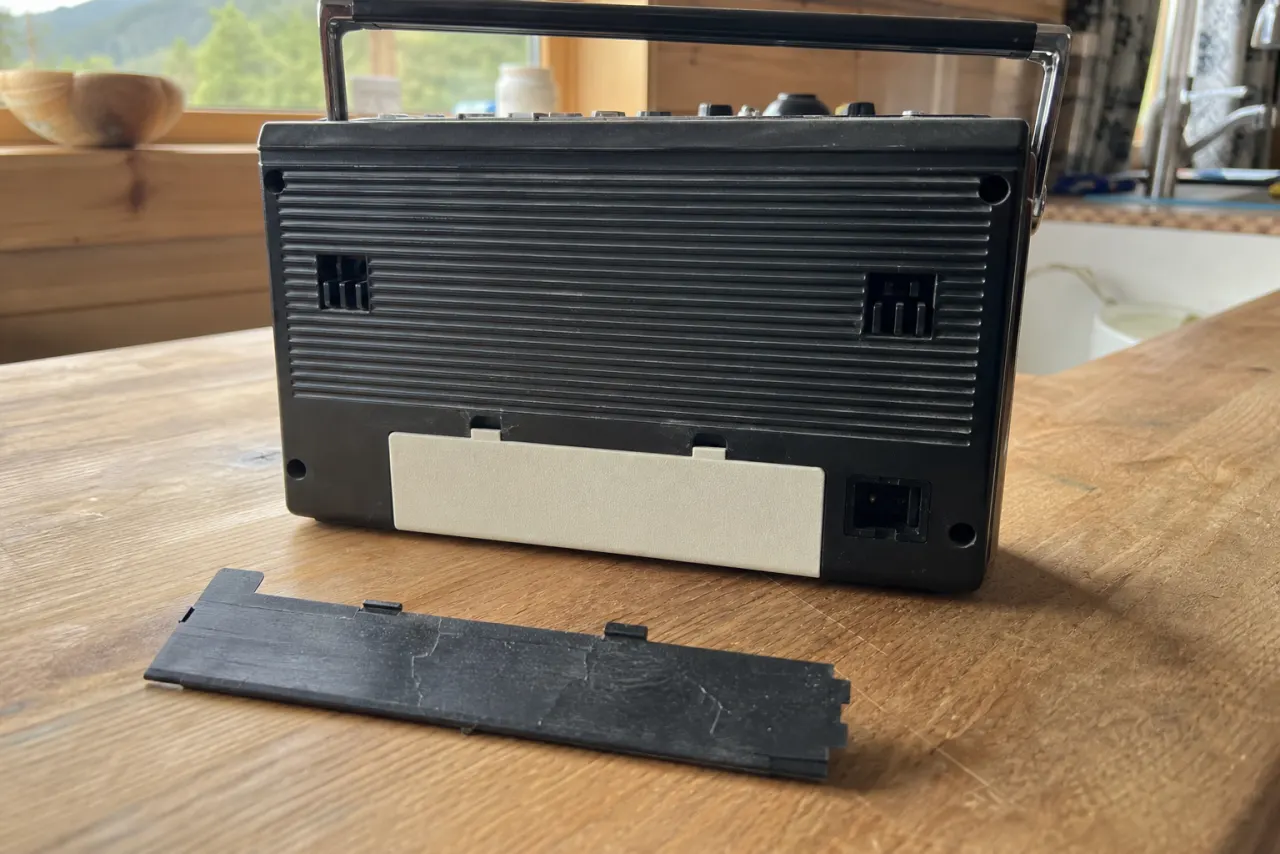 Nytt 3D-printet batterilokk på en gammel radio, det sprukne lokket ved siden av