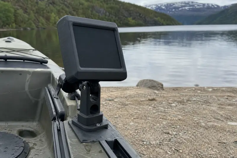 Svart 3D-printet feste med en avslått ekkoloddskjerm på dekket av en fiskekajakk ved et vann