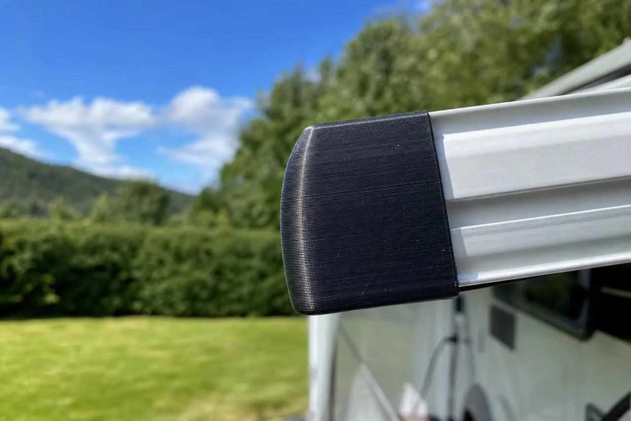 Svart 3D-printet endelokk på en markiseskinne
