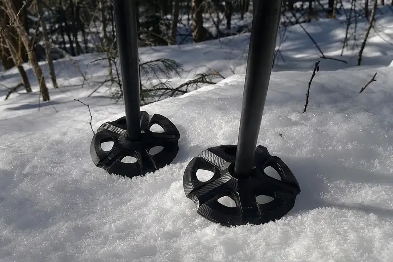 Nye svarte 3D-printede truger på gamle langrennsstaver i snøen
